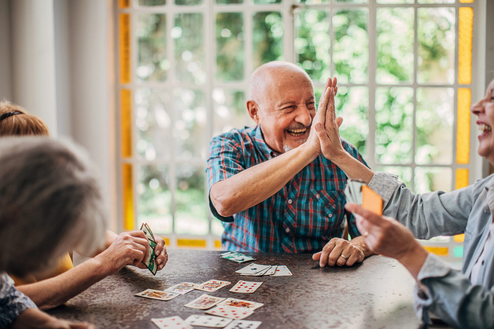 Group of people, senior people playing cards in nursing home.